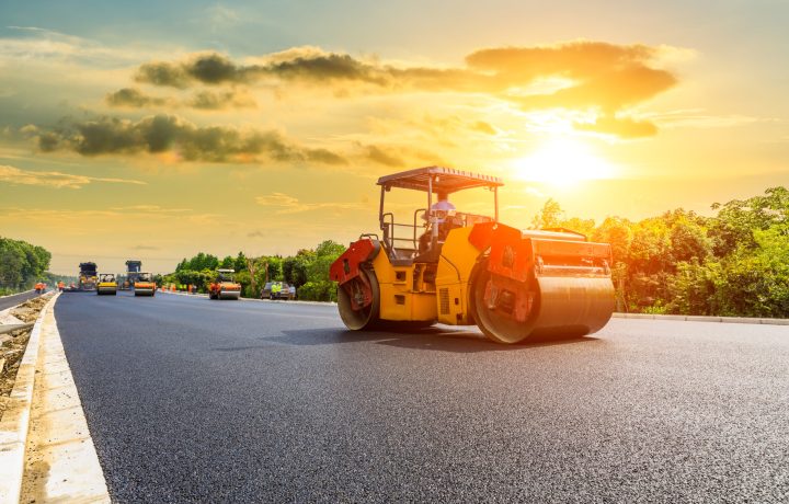 Construction site is laying new asphalt road pavement,road construction workers and road construction machinery scene.